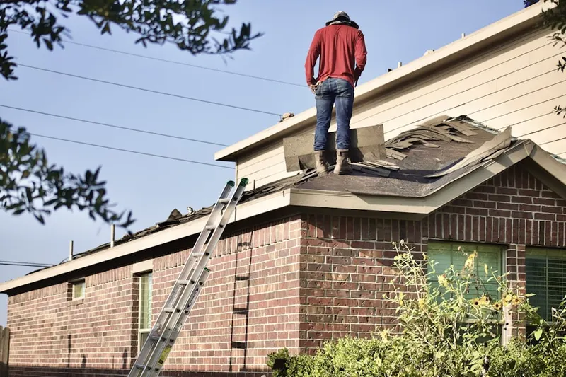 Professional roofer working on a residential roof in Poneto